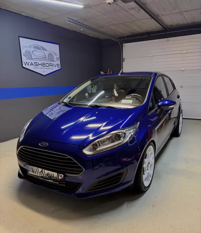 Blauer Ford Fiesta mit weißen Felgen, frisch gewaschen